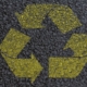 Front view of asphalt ground with recycle symbol painted on it