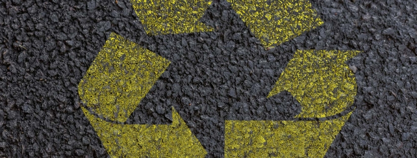 Front view of asphalt ground with recycle symbol painted on it