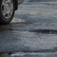 Side view of potholes on wet pavement