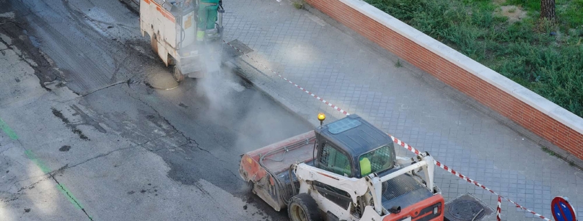 Two small milling asphalt machine driven by a worker in a street