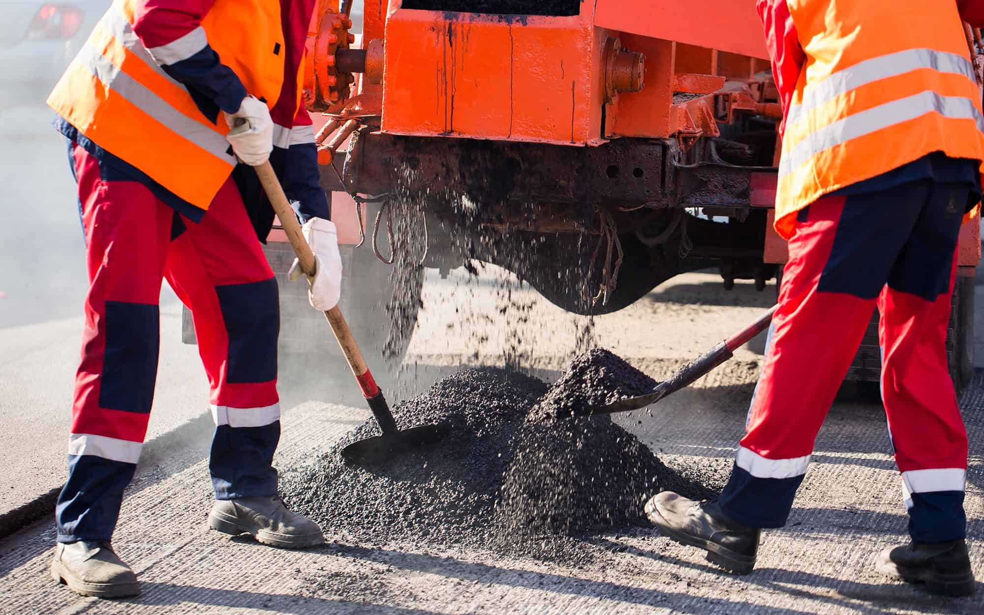 Workers Resurfacing Asphalt On Commercial Property
