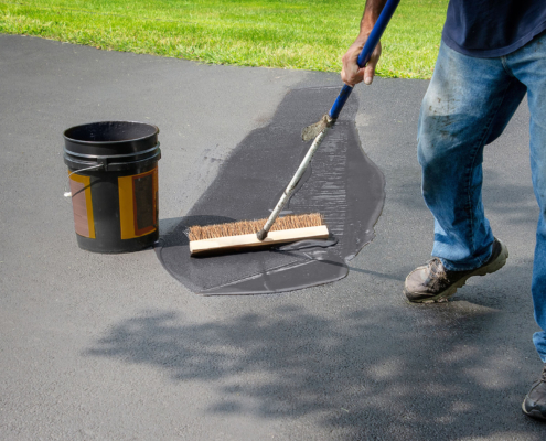 Homeowner Spreads Blacktop Asphalt Sealant On Driveway