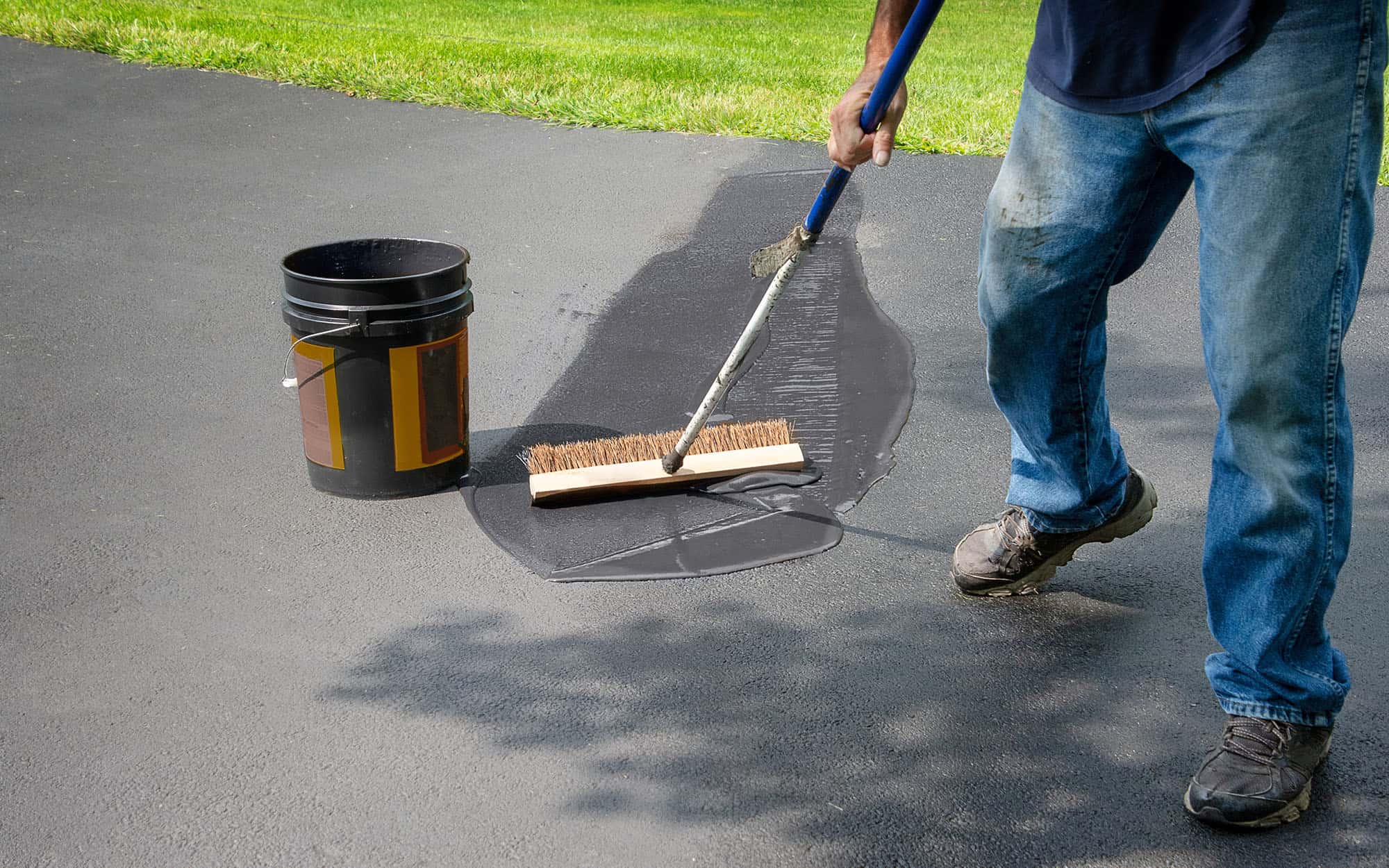 Homeowner Spreads Blacktop Asphalt Sealant On Driveway