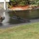 Worker Resurfacing Ashphalt Driveway