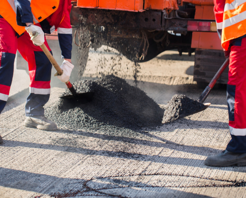 Young Builder On Asphalting Paver Machine During Road Street Repairing Works