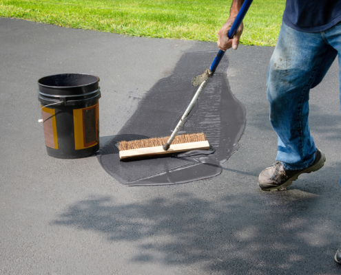 Worker Sealing Driveway