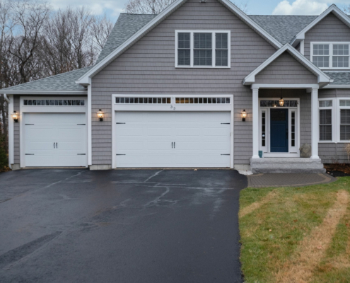 Gray Walled Suburban House With White Asphalt Driveway